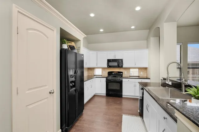 a kitchen with stainless steel appliances granite countertop a refrigerator stove and sink
