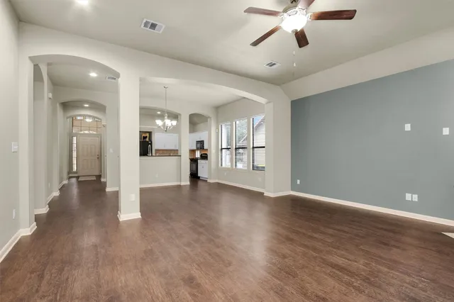 a view of an empty room and kitchen view