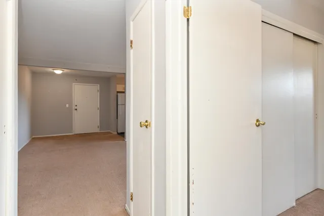 an empty room with windows and mirror