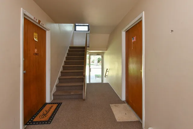 a view of a hallway with entryway and stairs
