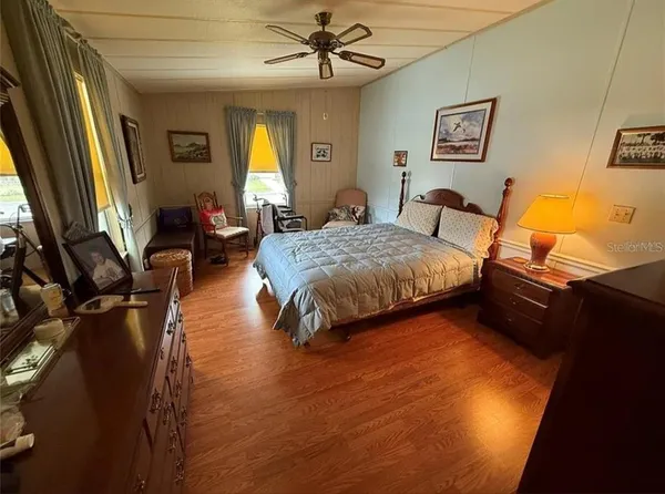 a spacious bedroom with a bed and wooden floor