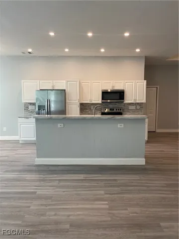 a kitchen with stainless steel appliances a refrigerator sink and microwave