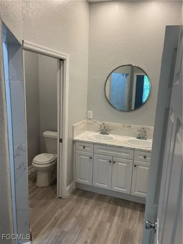 a bathroom with a toilet sink and mirror