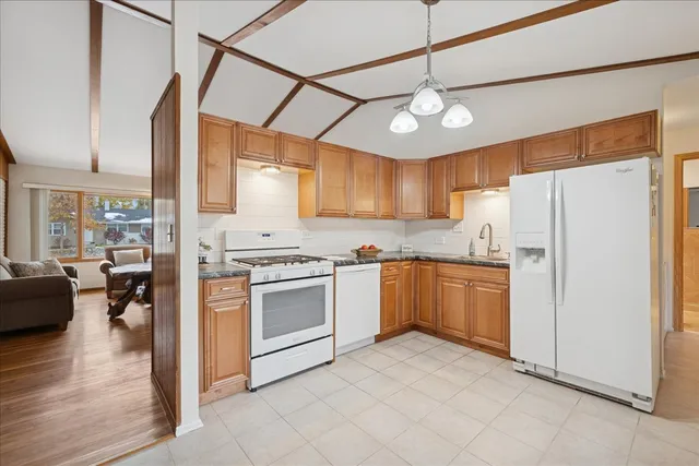 a kitchen with granite countertop a refrigerator and white cabinets