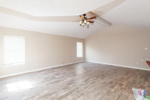 a view of a room with wooden floor and a ceiling fan