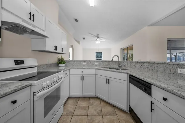 a kitchen with granite countertop cabinets stainless steel appliances and a counter space