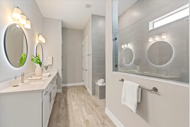 a bathroom with a double vanity sink mirror and a mirror