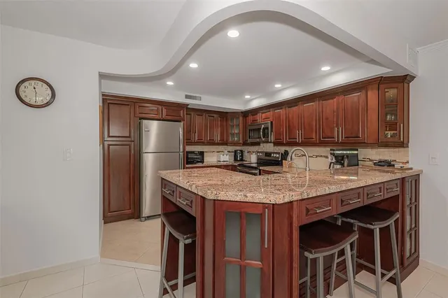a kitchen with stainless steel appliances granite countertop a stove a sink and a microwave