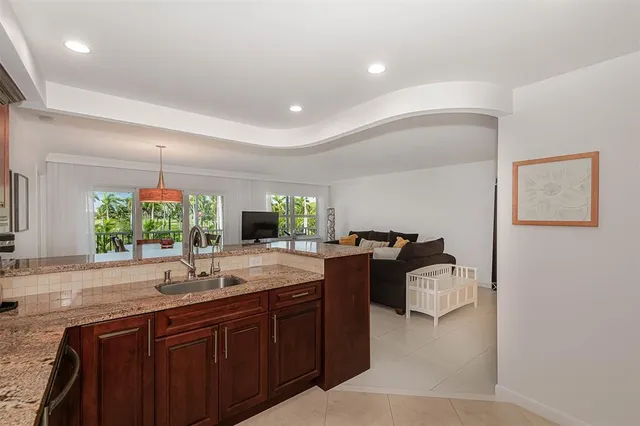 a view of a dining room and livingroom with furniture wooden floor a chandelier