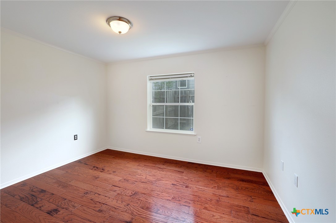 4607 Cedar Point Drive Austin, TX 78723 - Photo 15 of 27 an empty room with wooden floor and windows