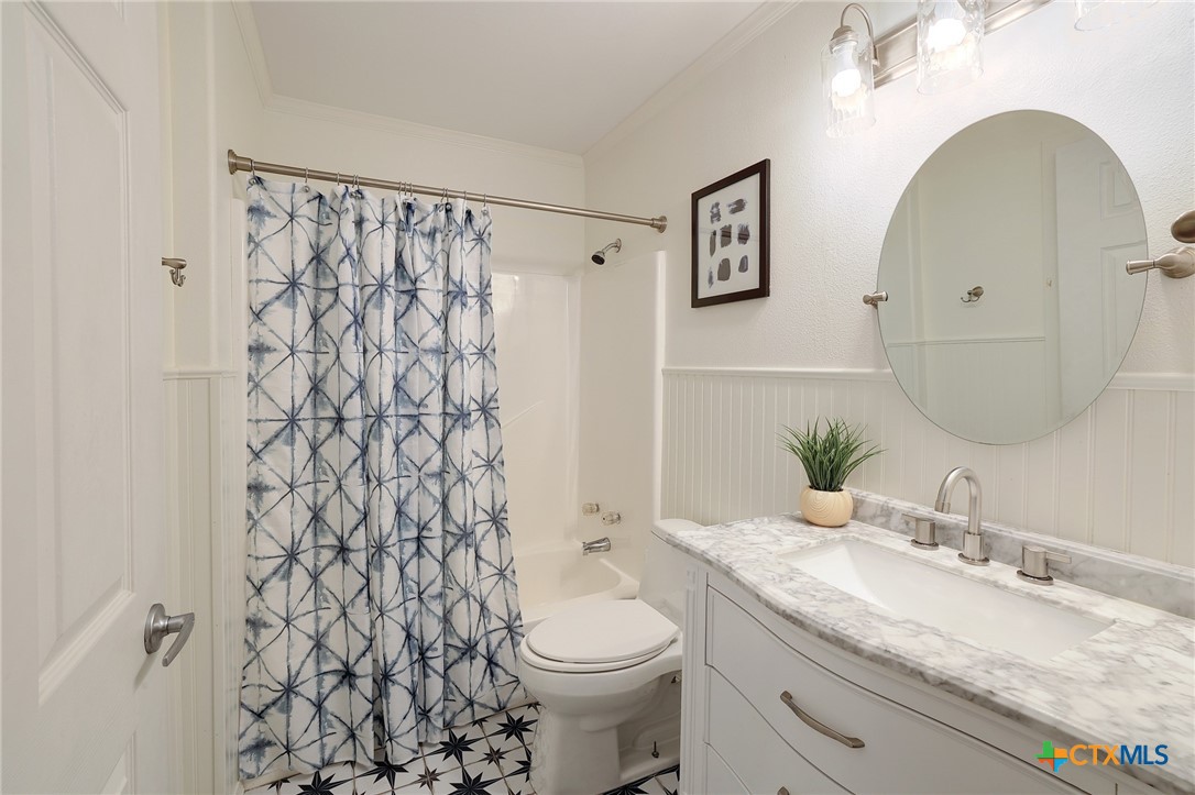 4607 Cedar Point Drive Austin, TX 78723 - Photo 16 of 27 a bathroom with a granite countertop sink and a mirror