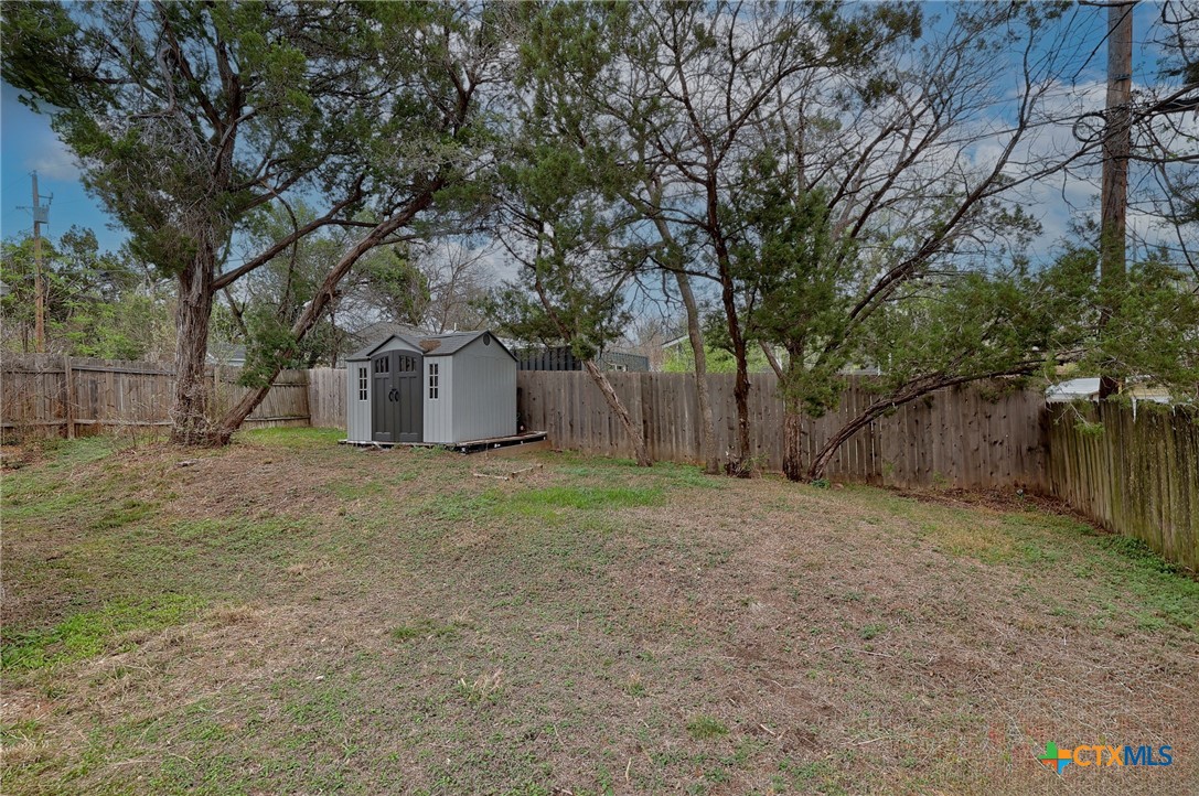 4607 Cedar Point Drive Austin, TX 78723 - Photo 19 of 27 a view of a backyard with large trees and wooden fence