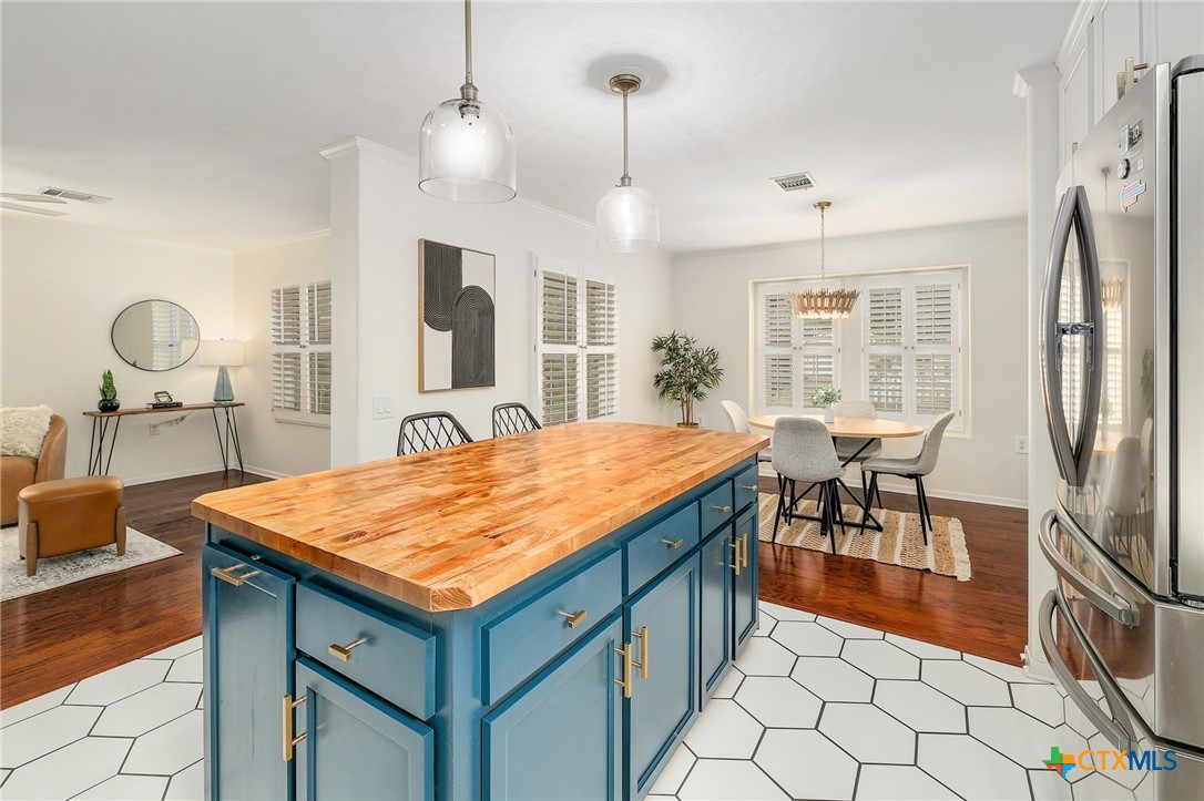 4607 Cedar Point Drive Austin, TX 78723 - Photo 8 of 27 a dining hall with stainless steel appliances granite countertop a stove refrigerator a dining table and chairs with wooden floor