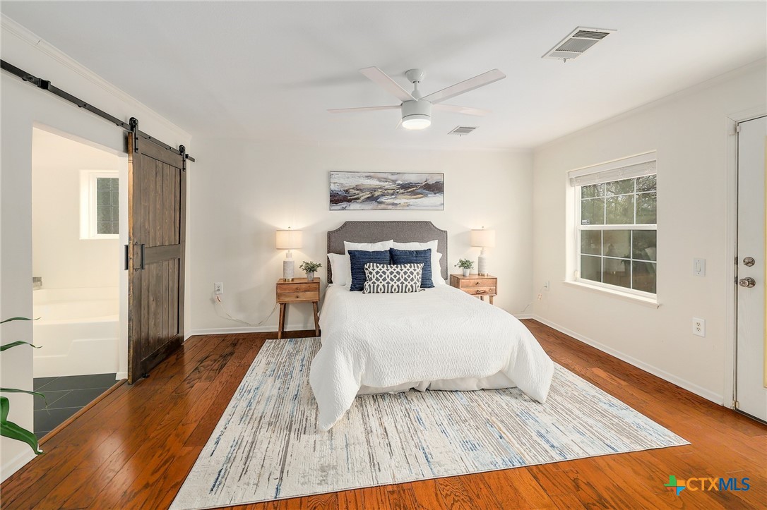 4607 Cedar Point Drive Austin, TX 78723 - Photo 9 of 27 a bedroom with a large bed and a window