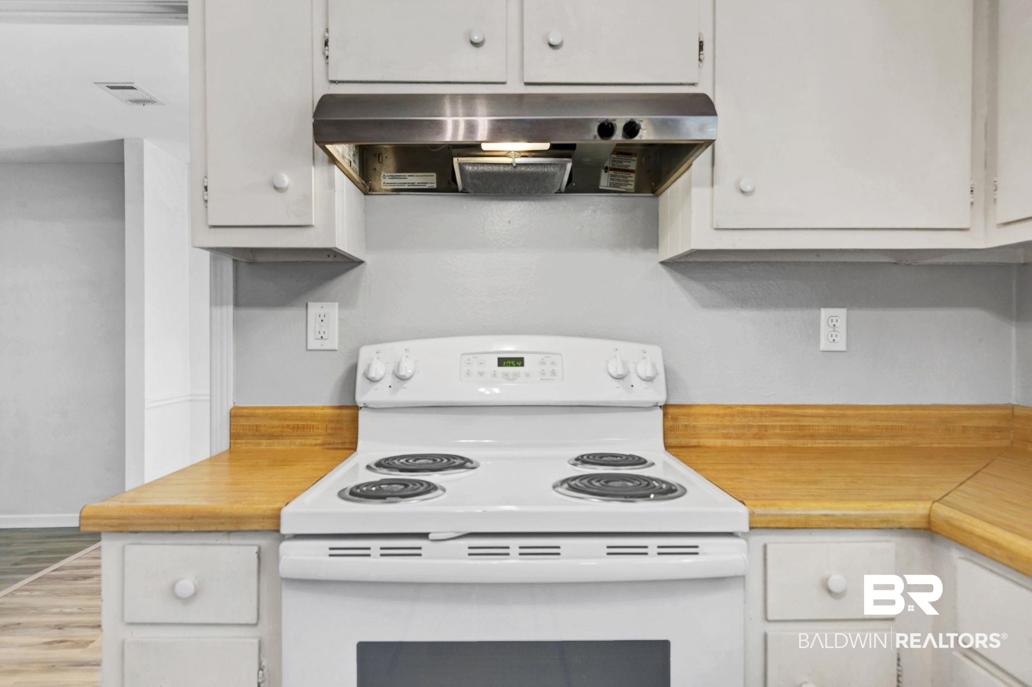 5817 Woodgate Road Mobile, AL 36609 - Photo 26 of 85 Kitchen featuring under cabinet range hood, electric range, white cabinetry, visible vents, and light countertops