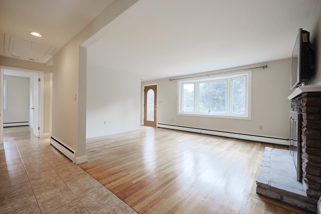 8 Greenwood Road Ashland, MA 01721 - Photo 5 of 29 an empty room with wooden floor mirror and windows
