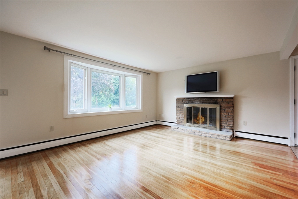 8 Greenwood Road Ashland, MA 01721 - Photo 6 of 29 wooden floor fireplace and windows in an empty room