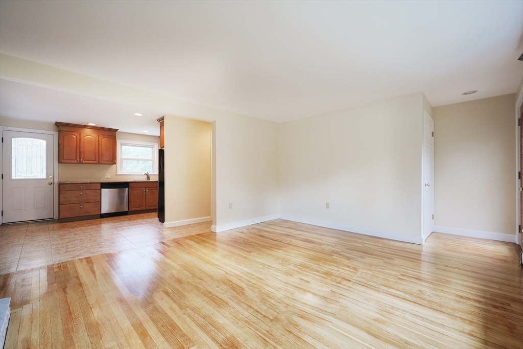 8 Greenwood Road Ashland, MA 01721 - Photo 7 of 29 a view of a livingroom with wooden floor and a kitchen space
