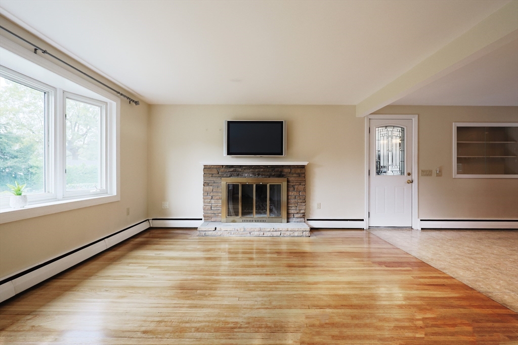 8 Greenwood Road Ashland, MA 01721 - Photo 8 of 29 a view of an empty room with a fireplace and a window