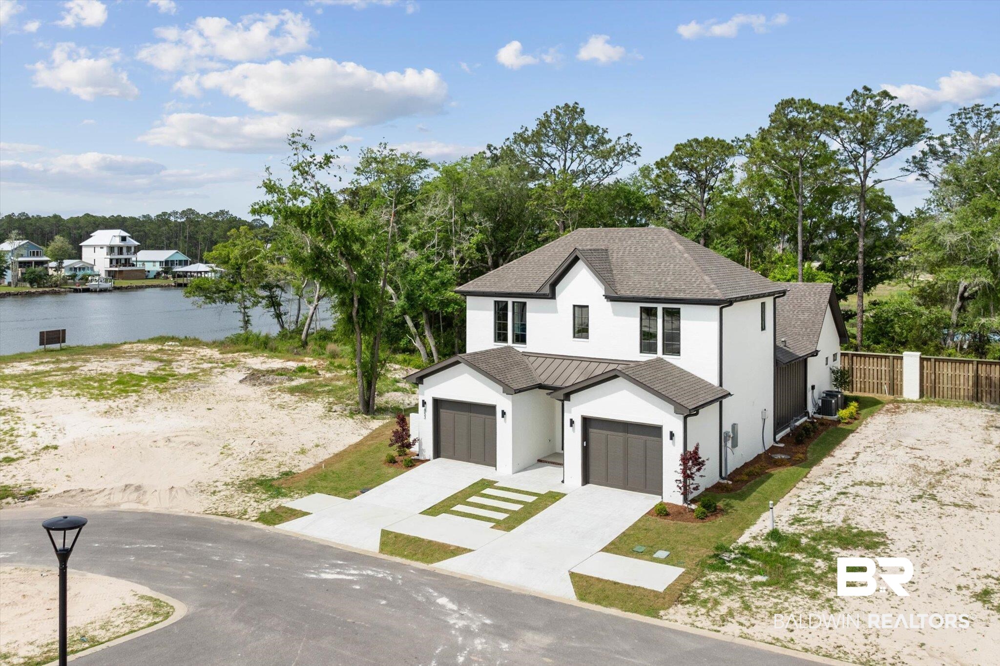 853 Inlet Circle Gulf Shores, AL 36542 - Photo 44 of 55 Modern farmhouse style home featuring a standing seam roof, metal roof, driveway, a water view, and stucco siding