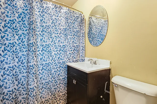 a bathroom with a sink a toilet and a mirror