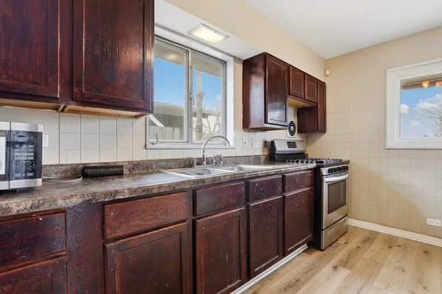 a kitchen with stainless steel appliances granite countertop a sink stove and microwave