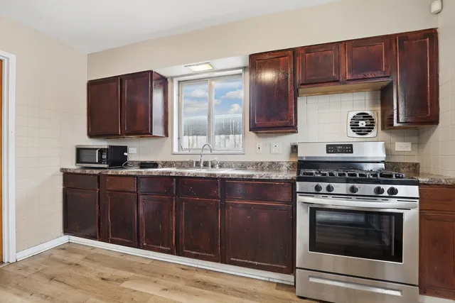 a kitchen with stainless steel appliances wooden cabinets and a stove top oven
