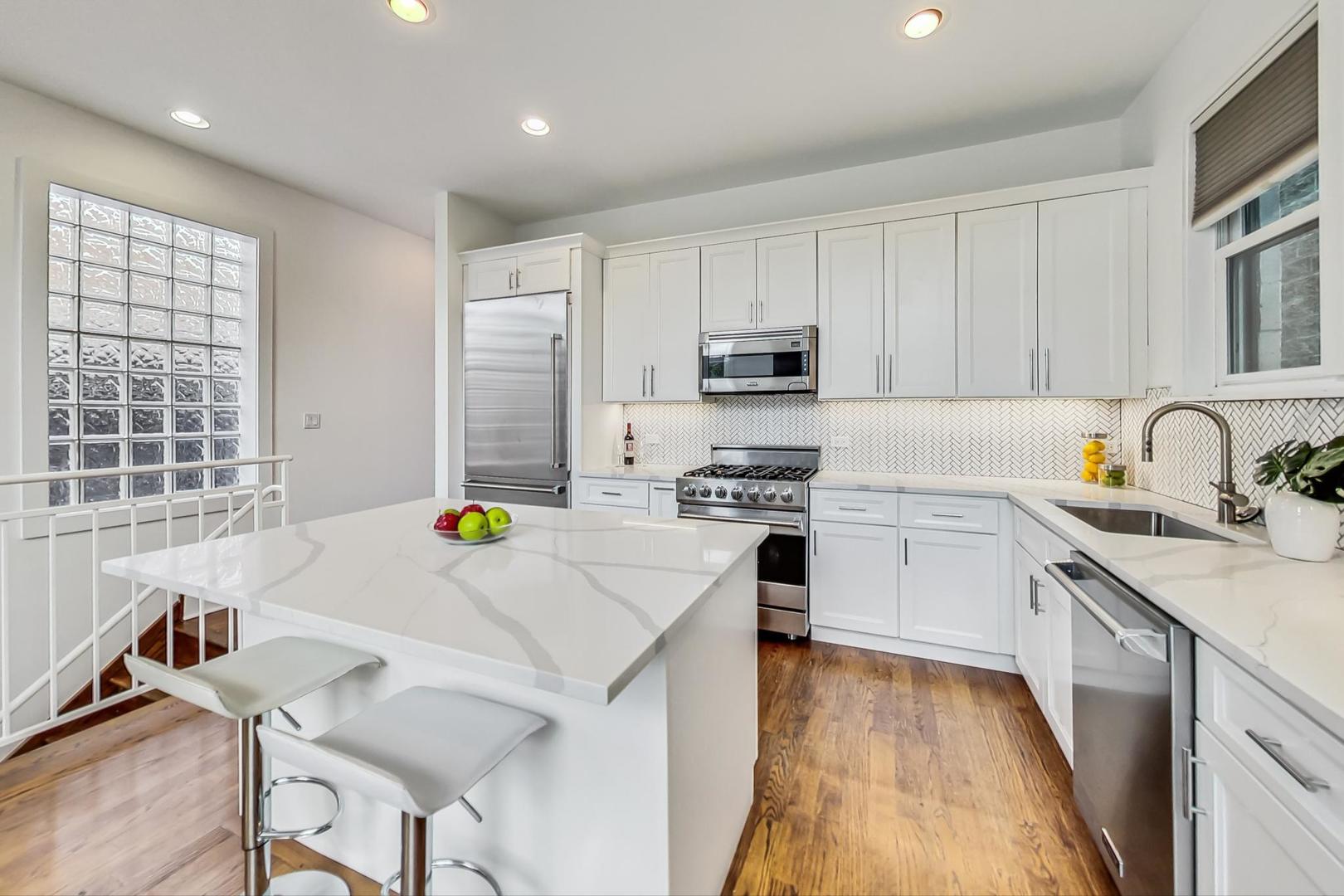 2035 North Leavitt Street, Unit 2 Chicago, IL 60647 - Photo 7 of 44 a kitchen with a sink a stove a refrigerator cabinets and wooden floor