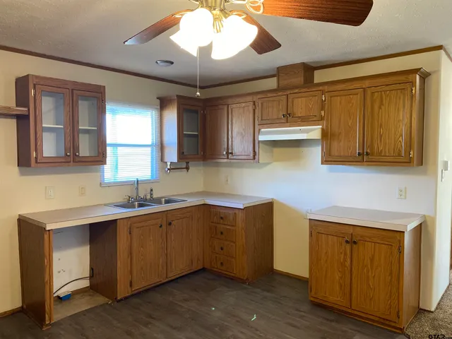 a kitchen with cabinets a sink stainless steel appliances and window