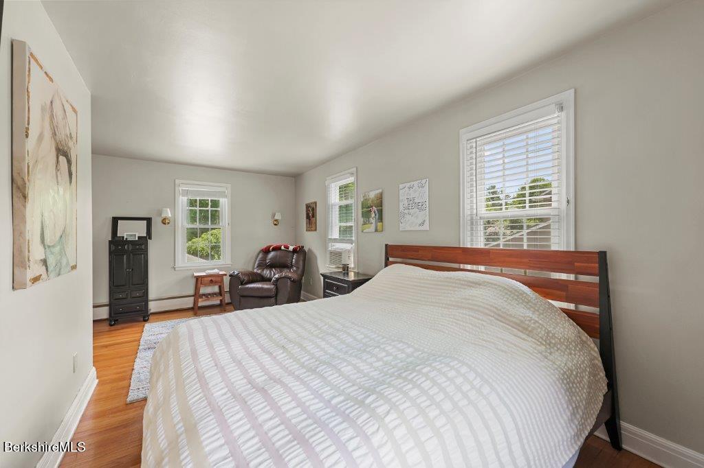 33 Eleanor Road Pittsfield, MA 01201 - Photo 30 of 45 a spacious bedroom with a bed a table and large windows
