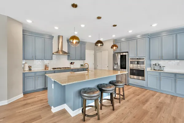 a kitchen with stainless steel appliances granite countertop a stove refrigerator and cabinets