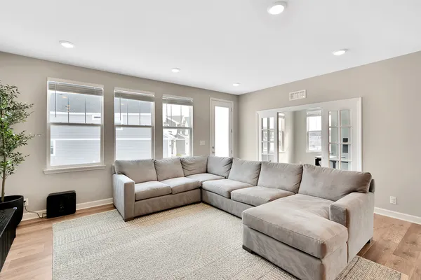 a living room with furniture kitchen view and a window