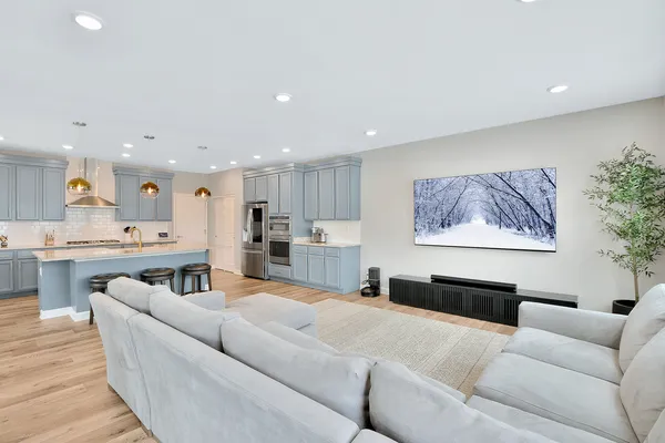 a living room with furniture and a dining table with kitchen view