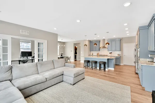 a dining room with furniture a chandelier and wooden floor