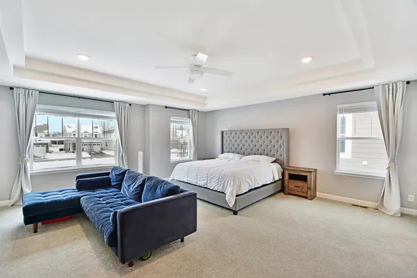 a spacious bedroom with a bed couch and window