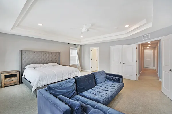 a spacious bedroom with a bed and a couch