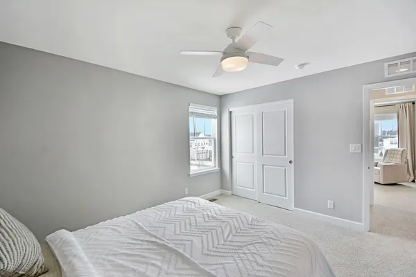 a bedroom with a bed and a ceiling fan