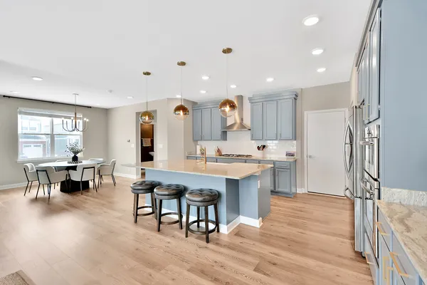a large kitchen with stainless steel appliances kitchen island granite countertop a large island in the center