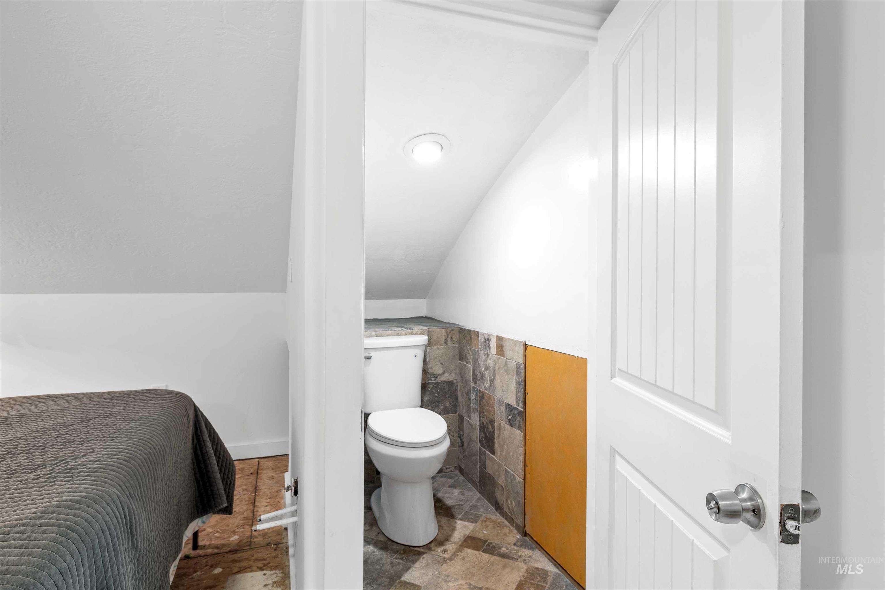 2039 Main Street Gooding, ID 83330 - Photo 16 of 31 Bathroom featuring stone finish flooring and vaulted ceiling