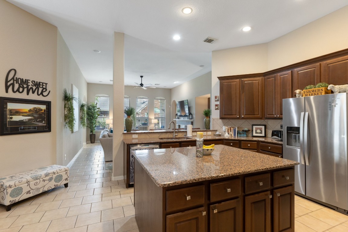 20410 Misty Crossing Lane Spring, TX 77379 - Photo 11 of 50 This photo showcases a spacious open-plan kitchen and living area. The living area, visible in the background, offers ample natural light from large windows