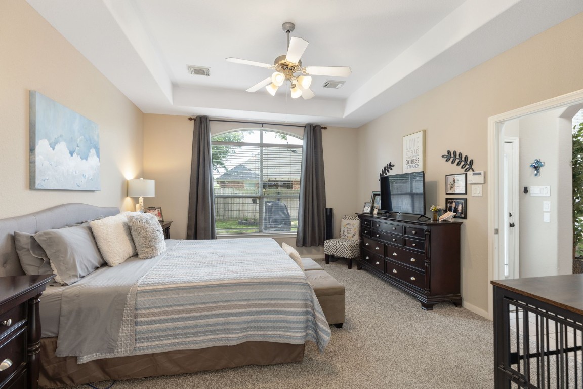 20410 Misty Crossing Lane Spring, TX 77379 - Photo 21 of 50 This spacious bedroom features a large window with abundant natural light, a ceiling fan, and cozy carpeting.