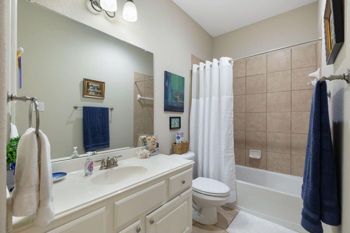 20410 Misty Crossing Lane Spring, TX 77379 - Photo 26 of 50 This bathroom is located by the upfront bedroom and features a large mirror, a light fixtures and a spacious vanity with ample storage. It includes a bathtub with tiled walls, complemented by tasteful decor and a neutral color palette for a soothing atmosphere.