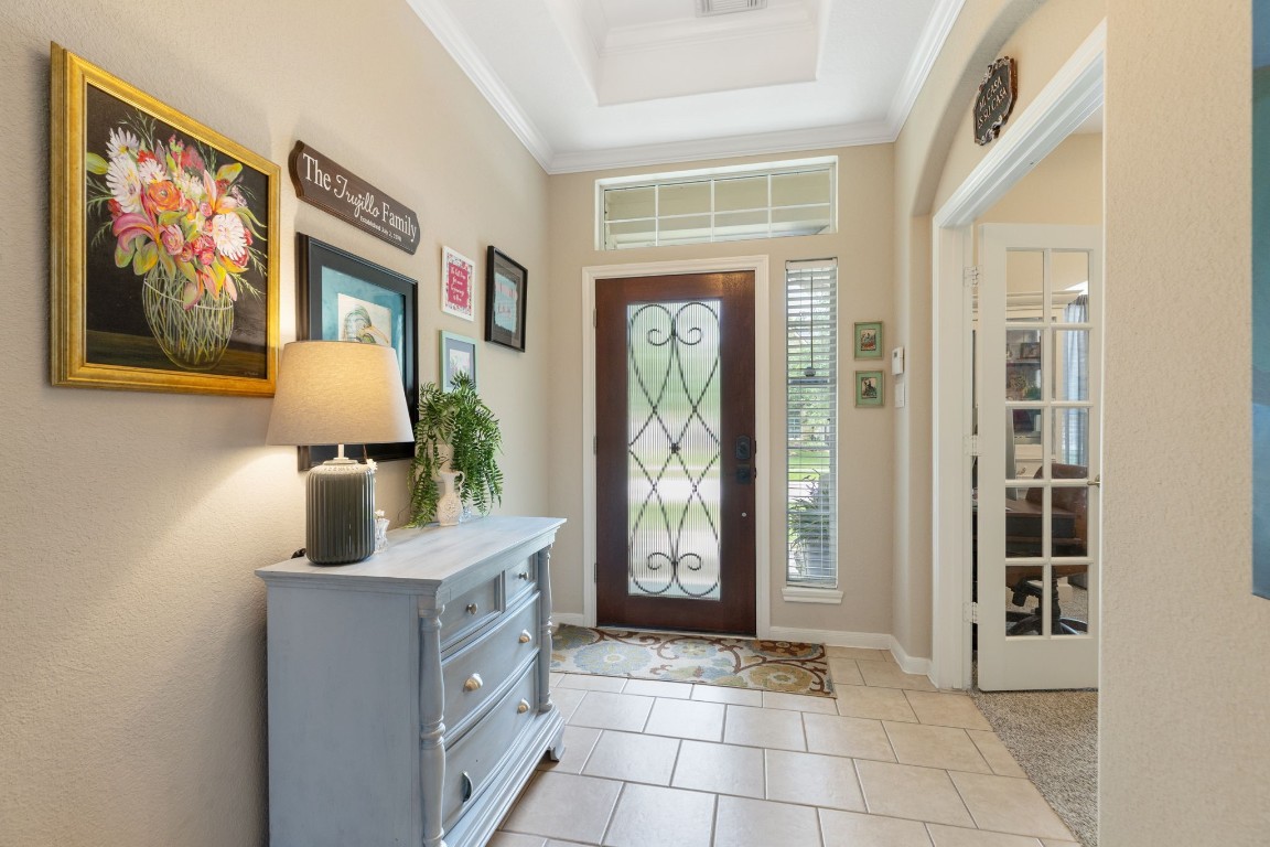 20410 Misty Crossing Lane Spring, TX 77379 - Photo 6 of 50 This inviting entryway features a stylish wooden front door with decorative glass panels, tile flooring, and plenty of natural light