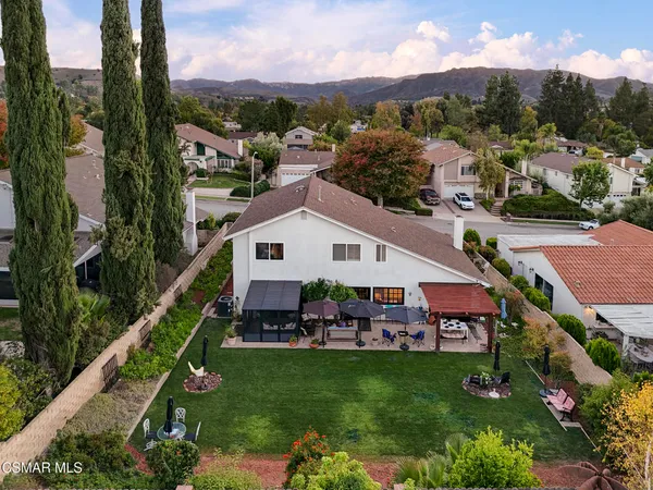 a aerial view of a house with a big yard and large trees