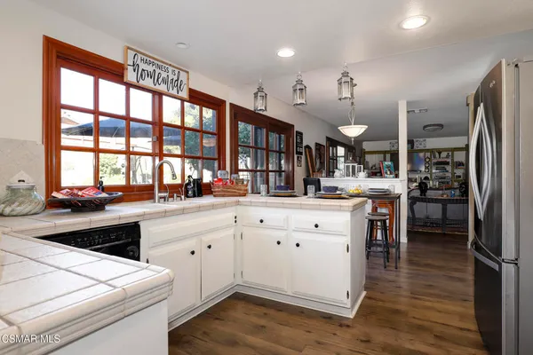 a kitchen with white cabinets and refrigerator