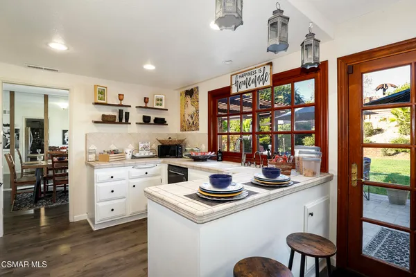 a kitchen that has a lot of cabinets in it and wooden floors