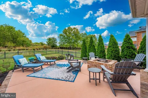 a kitchen with stainless steel appliances granite countertop a stove a sink dishwasher a refrigerator and a fireplace with wooden floor