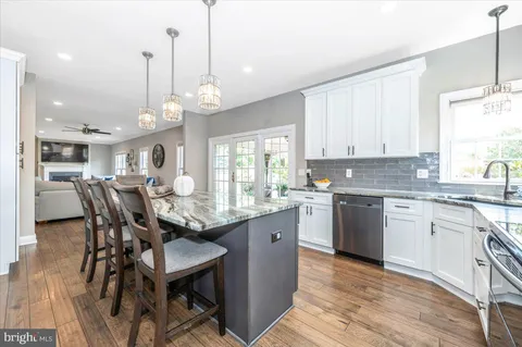 a dining room with stainless steel appliances kitchen island granite countertop a dining table chairs and granite counter tops