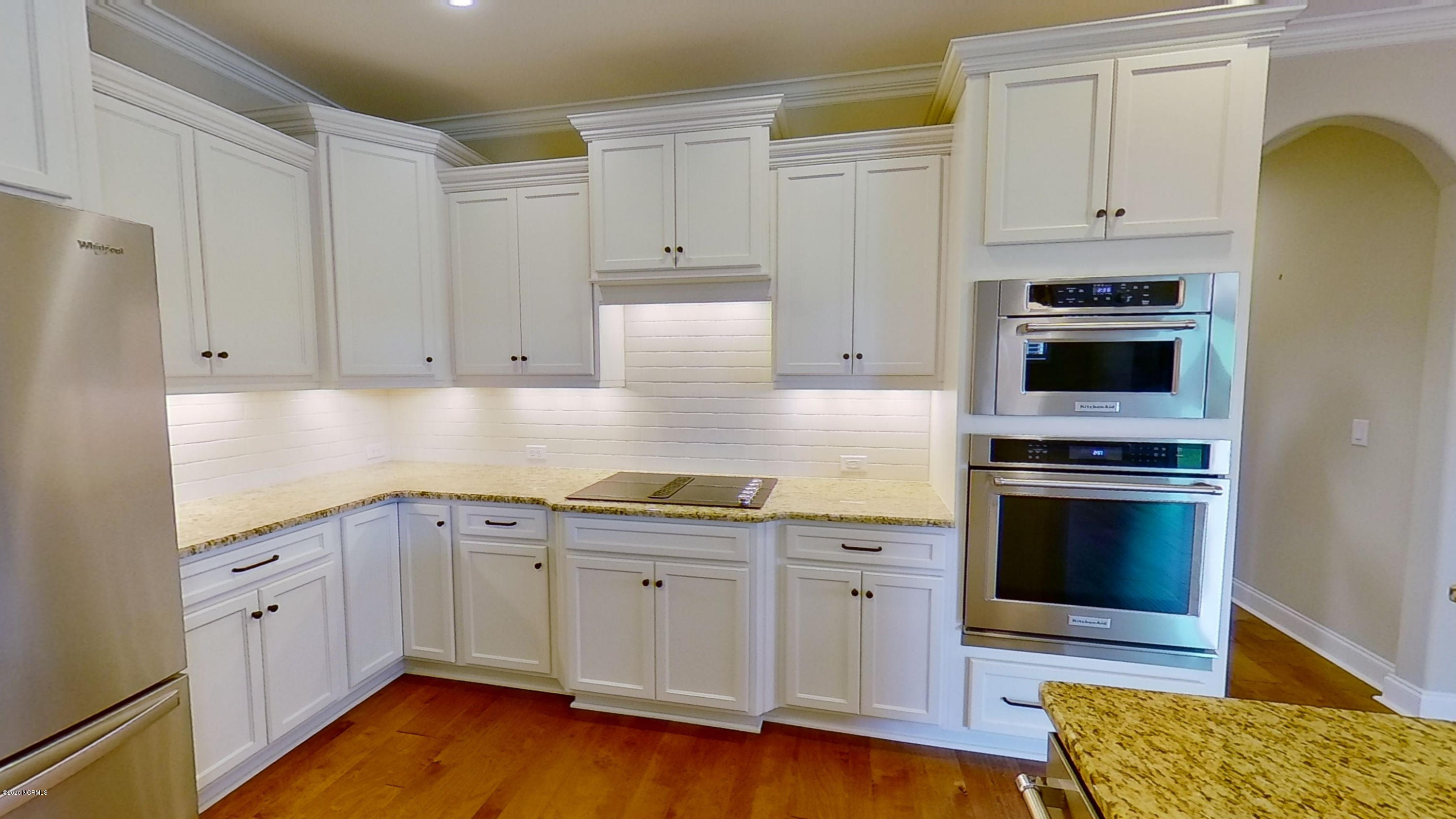 2140 Springstone Drive Leland, NC 28451 - Photo 17 of 38 Kitchen includes glass cooktop with downdraft, built-in microwave, and oven.