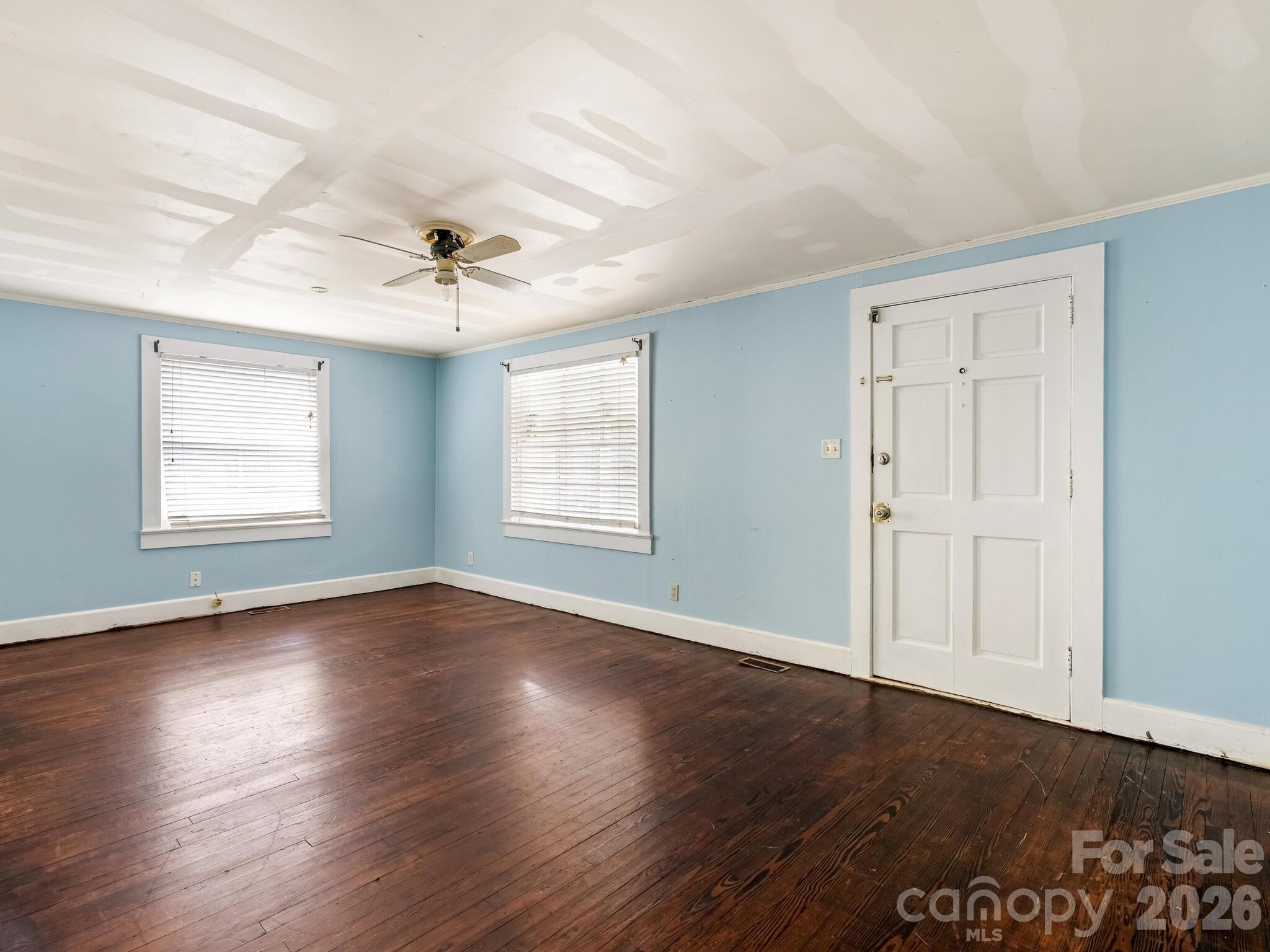2346 Sam Newell Road Matthews, NC 28105 - Photo 3 of 18 an empty room with wooden floor chandelier fan and windows